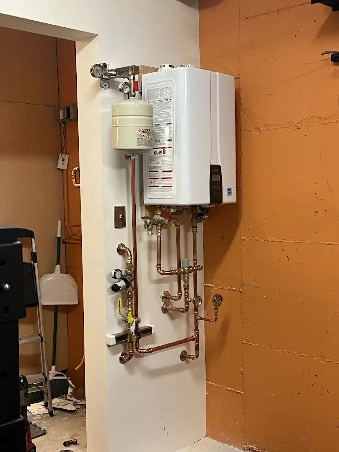 Plumbing technician inspecting water heater connections in Loyola